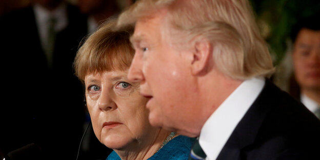 Angela Merkel guckt etwas ängstlich neben einem unbeirrt schauenden Trump