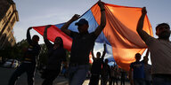 Menschen tragen eine riesige armenische Flagge über ihren Köpfen