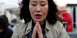 Eine Frau in Seoul legt ihre Hände zusammen, um für ein erfolgreiches Gipfeltreffen zu beten
