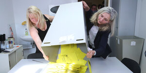 Mitarbeiterinnen der Stadtverwaltung schütten die Briefwahlunterlagen auf einen Tisch im Rathaus in Gera