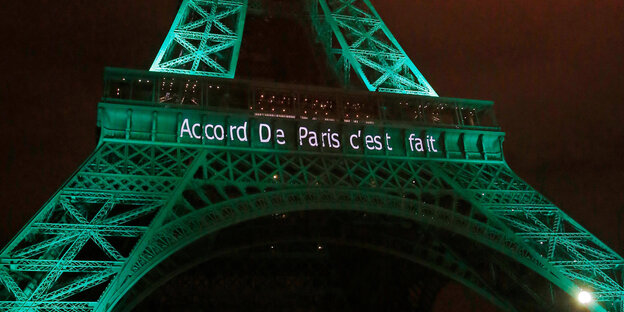 Der nachts in grün angestrahlte Eiffelturm mit der Aufschrift: „Das Pariser Abkommen ist fertig“