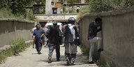 Ein Mann in Kabul weint gelehnt an eine Mauer über die Anschläge