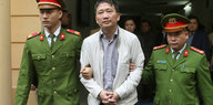 Trinh Xuan Thanh wird von zwei Uniformierten abgeführt