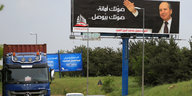 Lkws fahren an einem Wahlplakat für den ehemaligen libanesischen General Jamil al-Sayyed vorbei