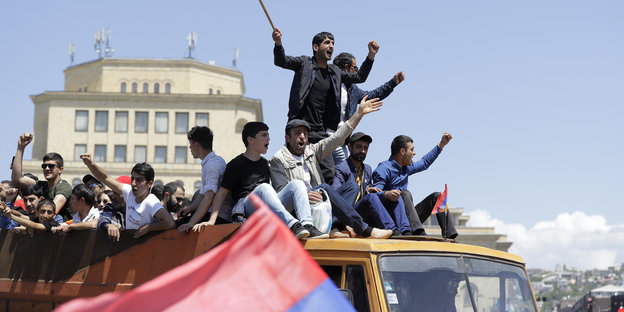 Unterstützer von Armeniens Oppositionsführer Paschinjan stehen auf einem Auto