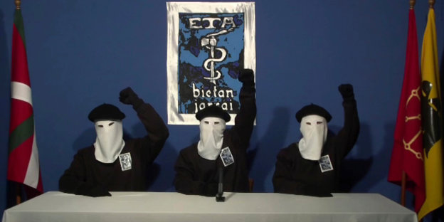 Drei maskierte Mitglieder der Separatistengruppe ETA recken die Fäuste in die Höhe