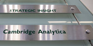 Ein Schild zeigt die Aufschrift "Cambridge Analytica"