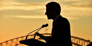 Emmanuel Macrons Silhouette vor orangegoldenem Abendhimmel