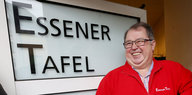 Jörg Sartor steht lächelnd neben dem Schild „Essener Tafel“