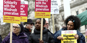 Frauen halten Schilder in die Höhe, auf denen „Solidarity with the Windrush Generation“ steht