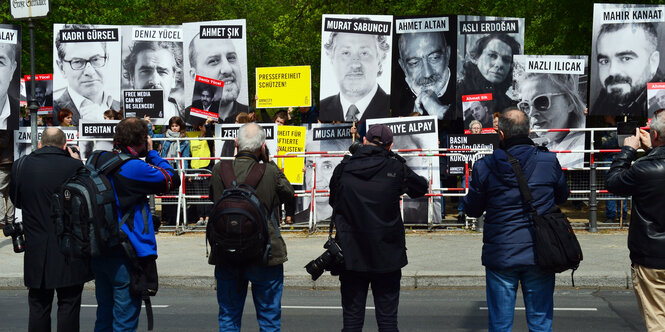 Fotografen fotografieren Plakate mit dem Konterfei von in der Türkei inhaftierten Journalisten