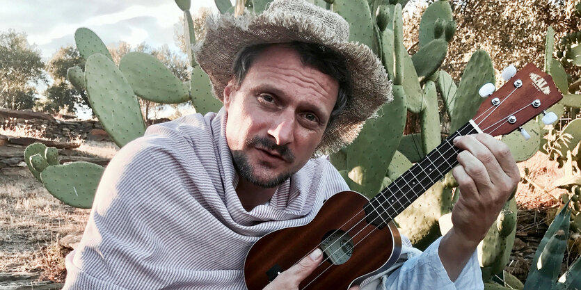 DJ Koze mit Ukulele vor Kaktus