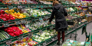 Kundin vor Gemüseregal im Supermarkt