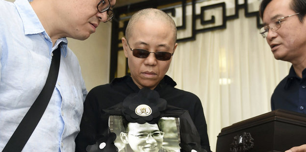 Eine Frau, Liu Xia, hält ein Foto von Liu Xiaobo in der Hand