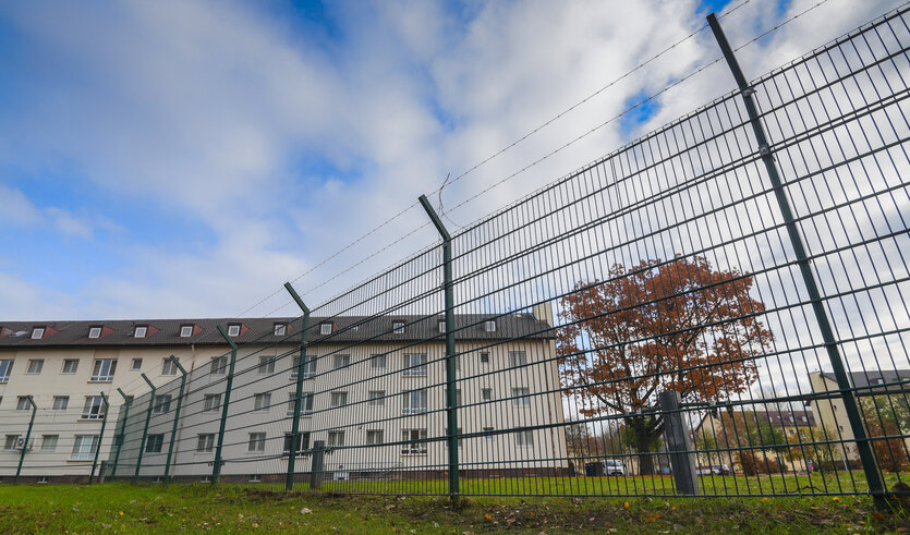 ein Gebäude hinter einem Stacheldrahtzaun