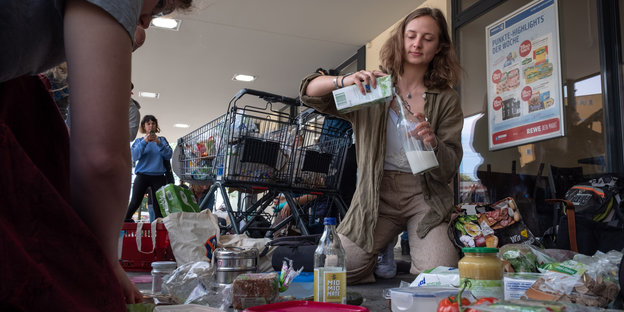 Vor einem Rewe-Supermarkt in Berlin werden die Lebensmittel in nachhaltige Gefäße umgefüllt