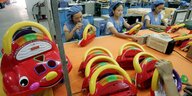 Arbeiterinnen in einer chinesischen Fabrik setzen Kassettenrekorder in Form von Spielzeugautos zusammen