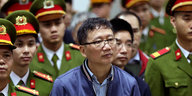 Trinh Xuan Thanh umringt von Uniform tragenden Männern
