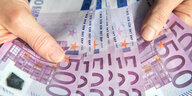 Zwei Hände halten viele 500-Euro-Geldscheine