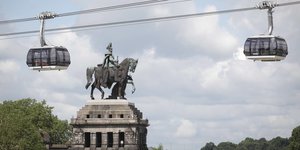 Das Kaiser-Wilhelm-Denkmal am Deutschen EcK, darüber schweben die Kabinen einer Seilbahn