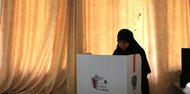 Eine Frau in einer Wahlkabine