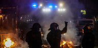Polizisten stehen vor einem Feuer