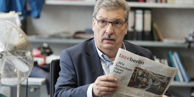 Parlamentspräsident Ralf Wieland in der taz-Redaktion mit einer Zeitung