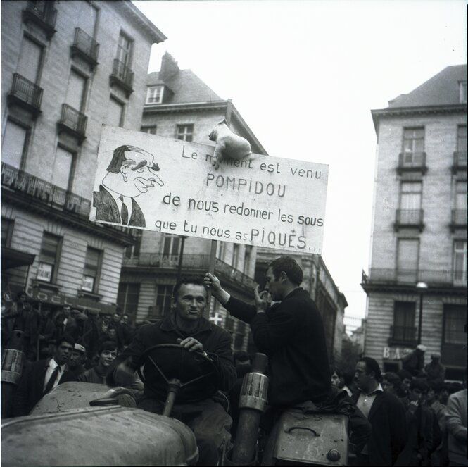 Menschen bei einer Demonstration, im Vordergrund sitzt ein Mann auf einem Traktor