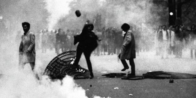 Proteste in Paris im Mai 1968, eine Frau wirft einen Stein