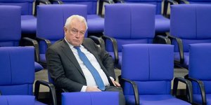 Ein Mann sitzt in den Sitzreihen des Bundestags, es ist Wolfgang Kubicki