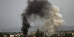Eine schwarz-weiße Rauchwolke steigt über der Stadt Nangarhar auf