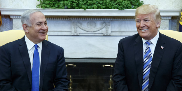 Netanjahu sitzt neben Trump, beide grinsen