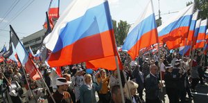 Menschen mit russischen Fahnen laufen auf der Straße