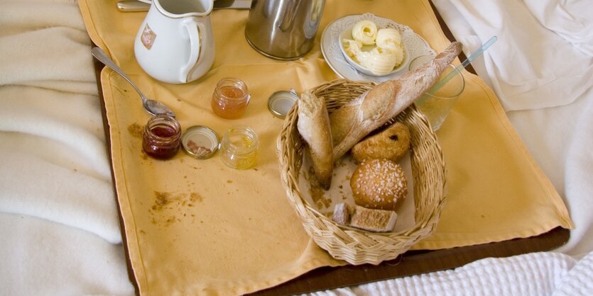 Tabeltt mit Frühstückszutaten auf einem Bett