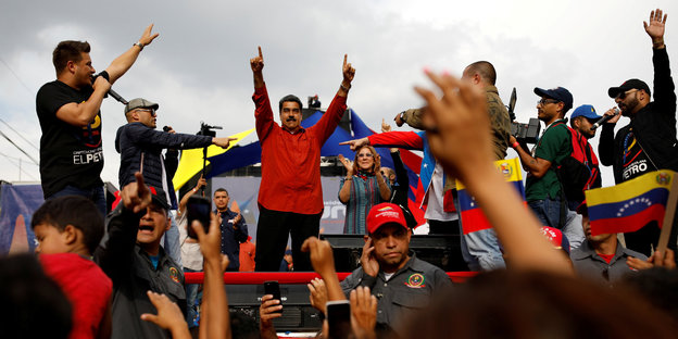 Maduro mit erhobenen Armen vor einer Menschenmenge