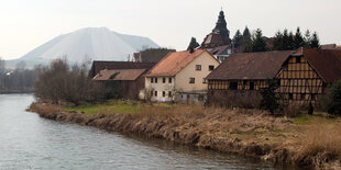 Häuser stehen an einm Fluss, dahinter ist ein Kali-Berg