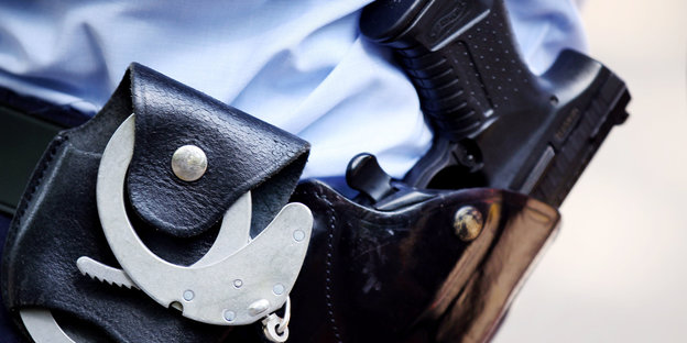 Das Halfter eines Polizisten, in dem eine Pistole und Handschellen zu sehen sind