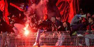 Nürnberg Fans feiern einen Treffer gegen Kiel und sitzen auf dem Zaun