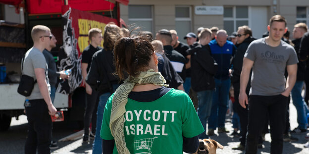 Person mit "Boycott Israel"-T-Shirt-Aufdruck auf einer Kundgebung