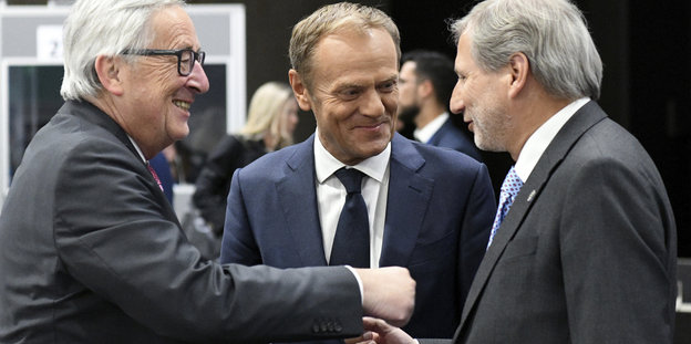 Jean-Claude Juncker, Donald Tusk und Johannes Hahn unterhalten sich lächelnd