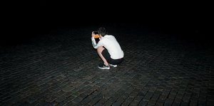 Ein junger Mensch fotografiert im Dunkeln