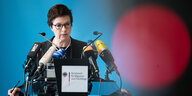 Eine Frau, Jutta Corft vom Bamf, spricht vor Mikrofonen. Blauer Hintergrund.