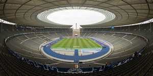 Blick ins Olympiastadion mit Zuschauernplätzen, Rasen und Laufbahn