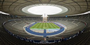 Blick ins Olympiastadion mit Zuschauernplätzen, Rasen und Laufbahn