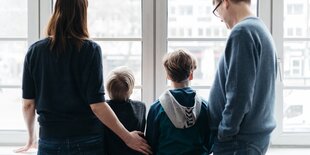 Familie von hinten am Fenster