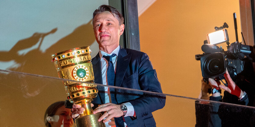 Ein Mann hält einen Pokal