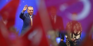 Erdogan winkt inmitten von Fahnen