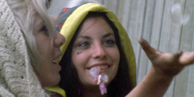 Grisseliges Bild: Zwei junge Frauen mit Kapuzen gucken begeistert einer Seifenblase nach