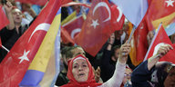 Eine Frau schwenkt Türkei-Flaggen in einer Menschenmenge
