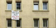 Ein Transparent hängt aus einem Fenster. Auf ihm steht: „Wir sind alle Wilhelm-Raabe-Straße 4“